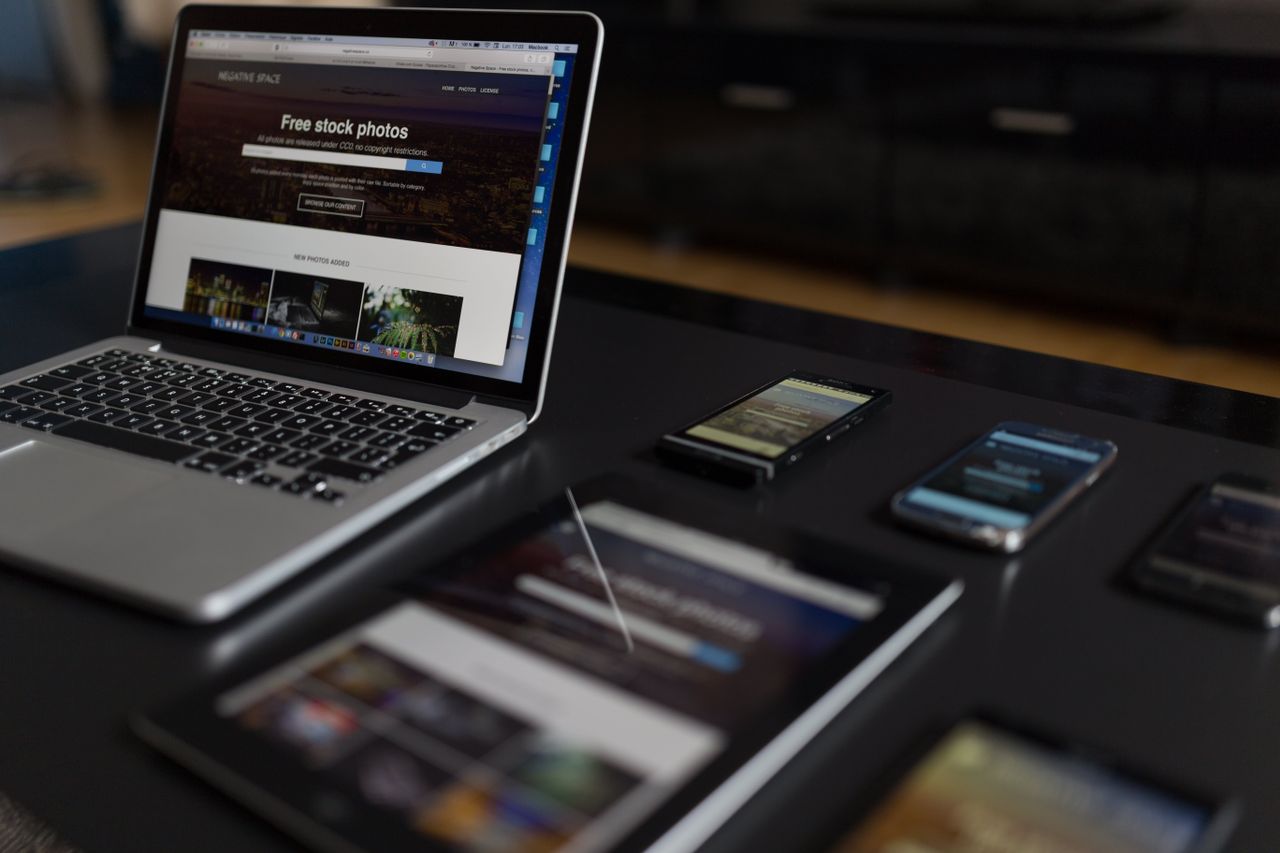 A modern workspace displaying a laptop, tablet, and smartphones, perfect for tech and freelance use.